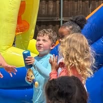 Children playing with water toys at an inflatable bounce house event