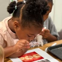 Young girl using a dropper over a craft project