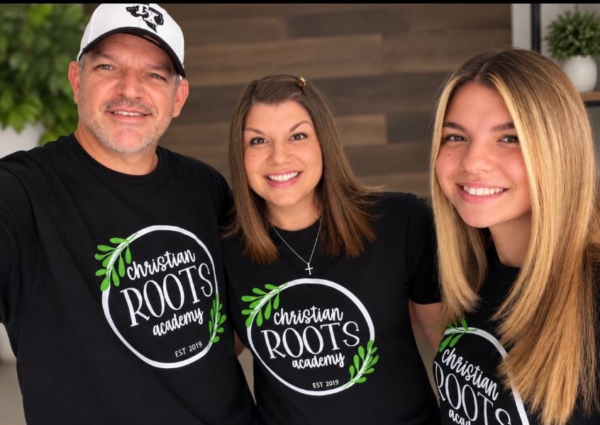 Family wearing matching Christian Roots Academy t-shirts