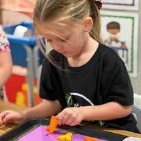 Child engaged in hands-on learning at Christian Roots Academy